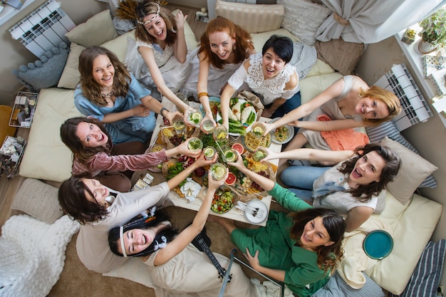 Top view group modern hippie female friends celebrating holiday at table serving with healthy food