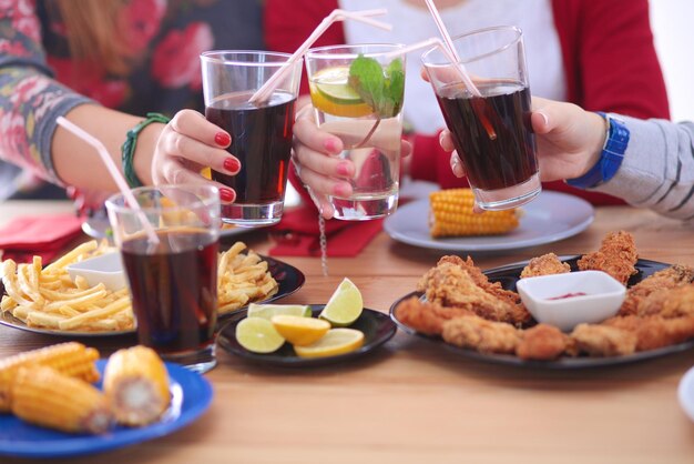 Top view of group of people having dinner together while\
sitting at wooden table food on the table people eat fast food