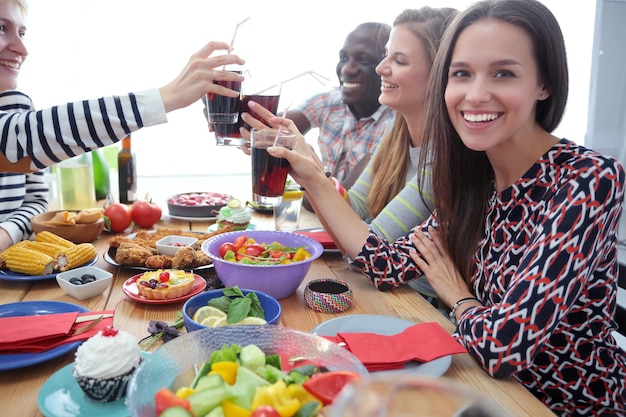 Top view of group of people having dinner together while\
sitting at wooden table food on the table people eat fast food