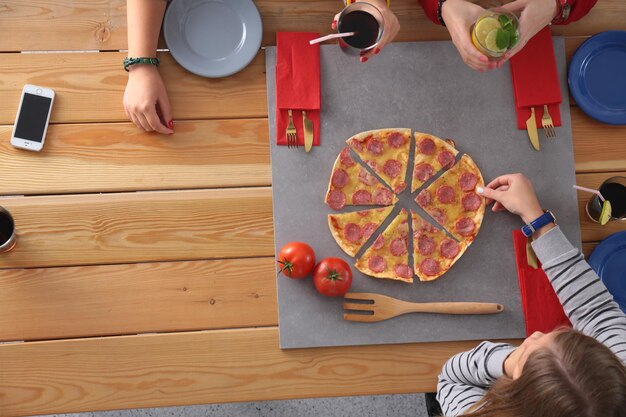 木製のテーブルに座って一緒に夕食を食べている人々のグループの上面図テーブルの上の食べ物人々はファーストフードを食べる