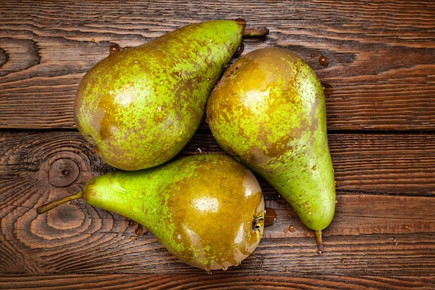 Top view of a group of wet pears on a dark wooden background