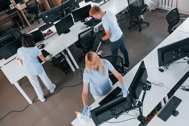 Top view Group of workers clean modern office together at daytime