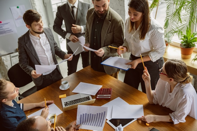 top view. group of young business professionals having a meeting. diverse group of coworkers discuss new decisions, plans, results, strategy. creativity, workplace, business, finance, teamwork.