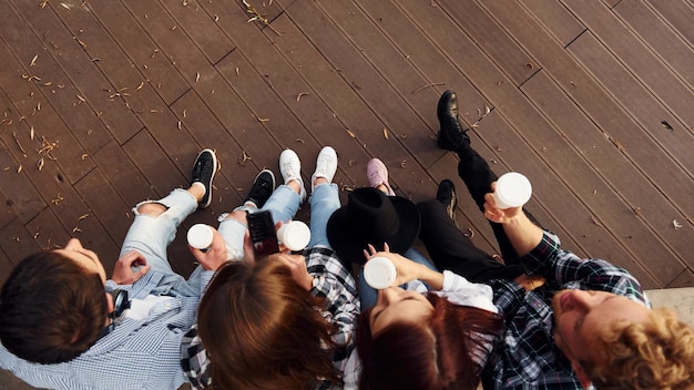 Top view of group of young cheerful friends that is outdoors having fun together