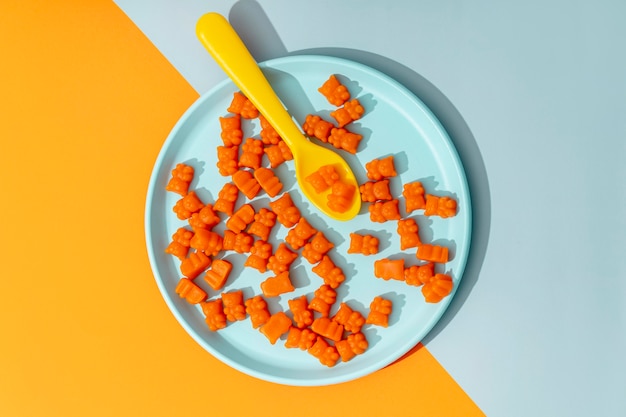 Photo top view of gummy bears on plate with spoon