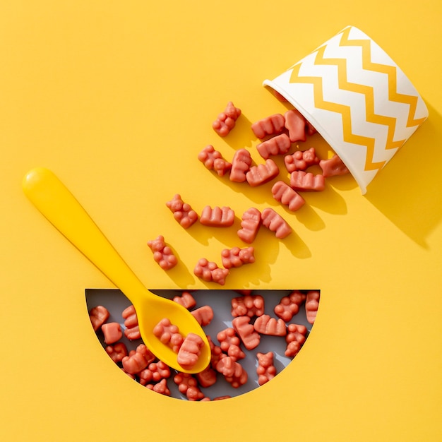 Top view of gummy bears with cup and spoon