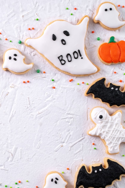 Vista dall'alto di biscotti di zucchero di panpepato glassa decorata festosa di halloween su priorità bassa bianca con lo spazio della copia e la disposizione piana della disposizione.