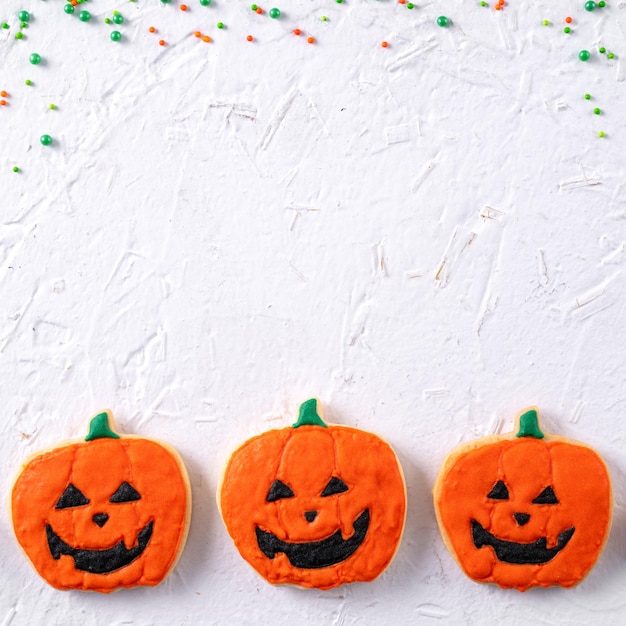 Top view of Halloween festive decorated icing sugar cookies on white background