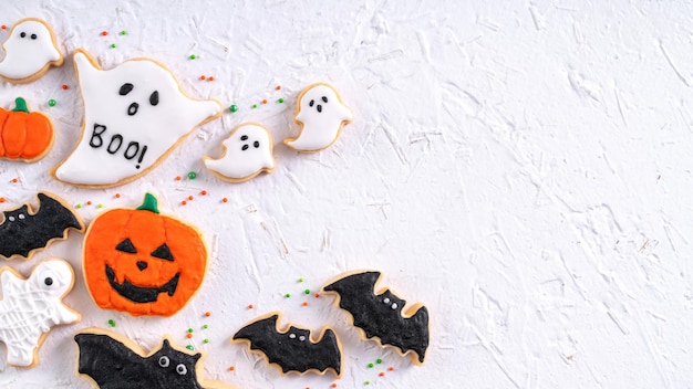 Top view of Halloween festive decorated icing sugar cookies on white background