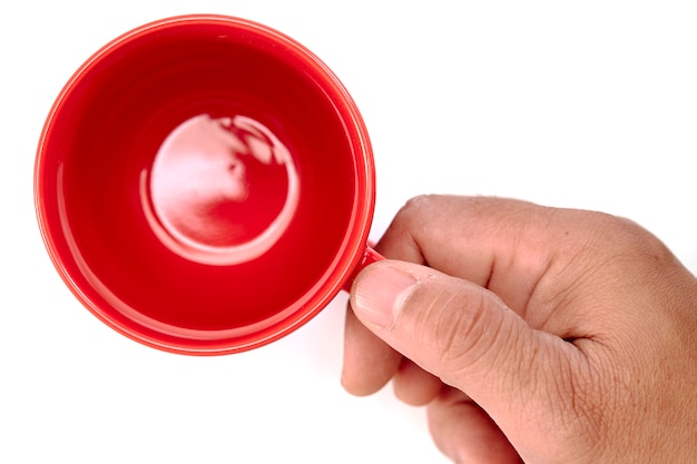 Top view hand holding empty red mug coffee