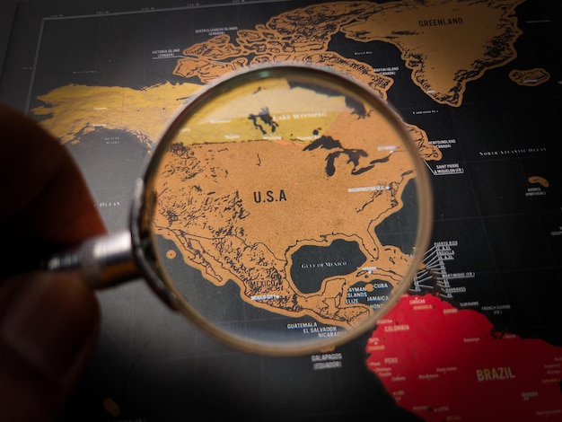 Top view hand holding magnifying glass and focus to USA map