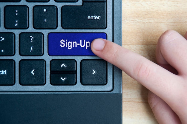 Photo top view of hand pressing sign-up button on laptop keyboard online business concept