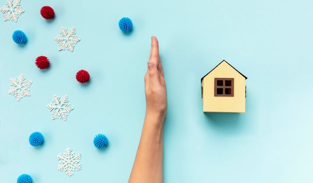 Foto mano di vista superiore che separa la casa di carta e le palle decorative