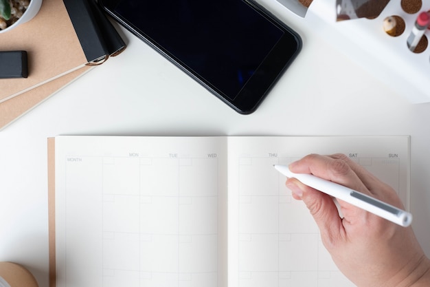 Top view of hand writing on open calendar planner for business resolution