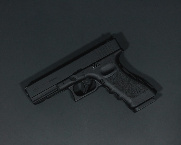 Top view of a handgun on a gray surface under the lights