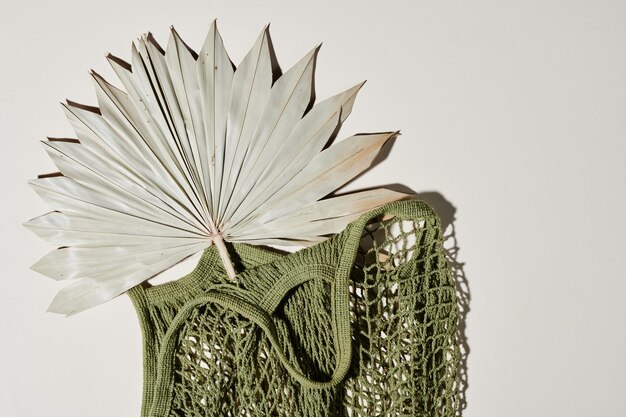 Top view of handmade knitted handbag of green color with fan
inside