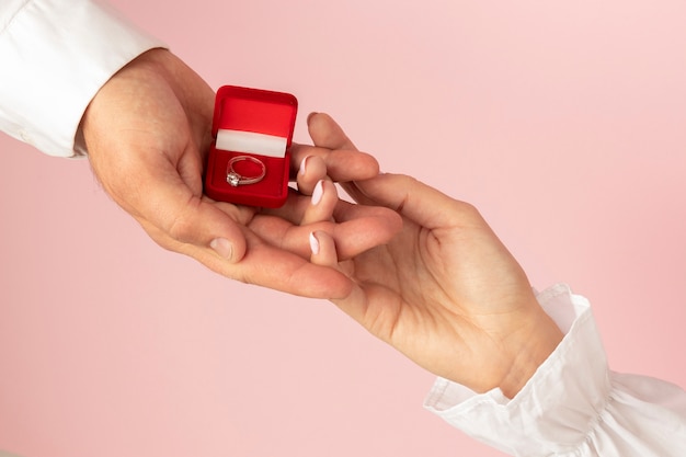 Photo top view of hands exchanging ring for valentines day