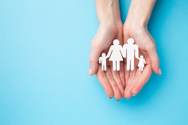 Top view hands holding family figure with copy space