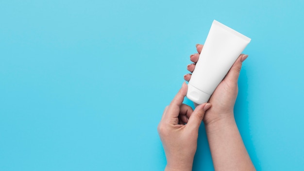 Top view of hands holding hydro alcoholic gel bottle with copy space