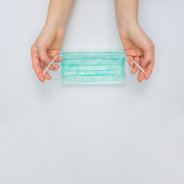 Top view of hands holding medical mask with copy space