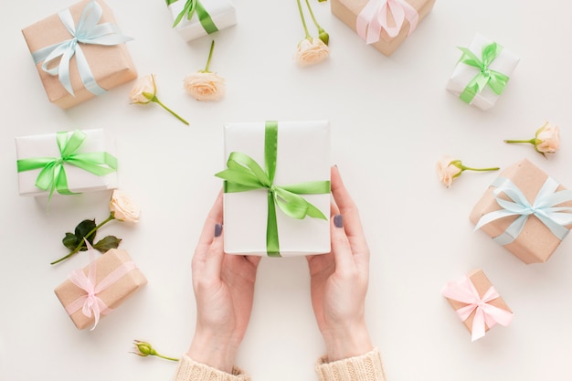 Photo top view of hands holding present with flowers