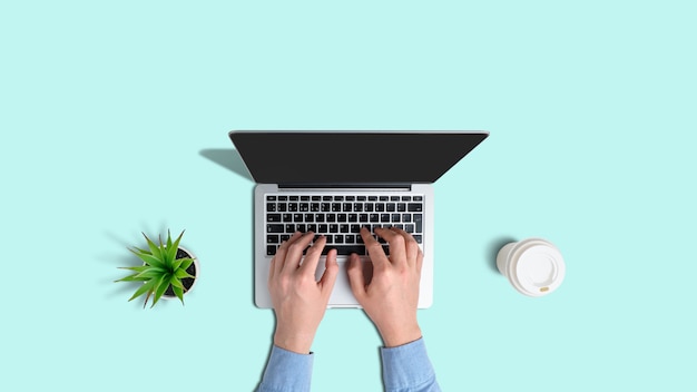 Top view of hands typing on laptop