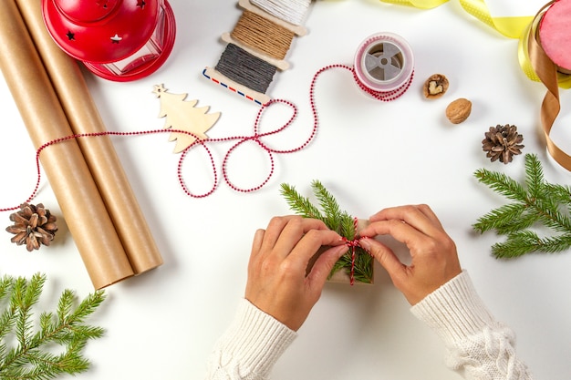 Foto vista dall'alto delle mani che avvolgono il regalo con strumenti diversi