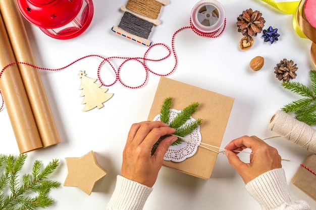 Top view of hands wrapping gift with different instruments