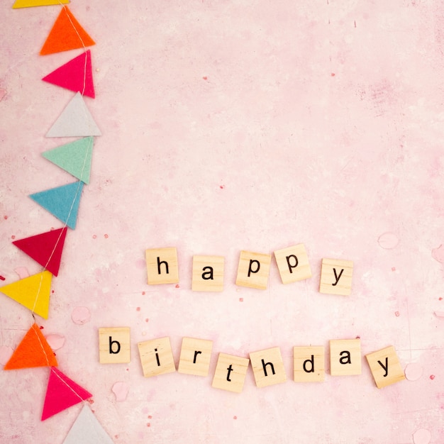 Photo top view of happy birthday wish in wooden letters with garland