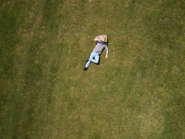 Top view of happy man lying on the green grass