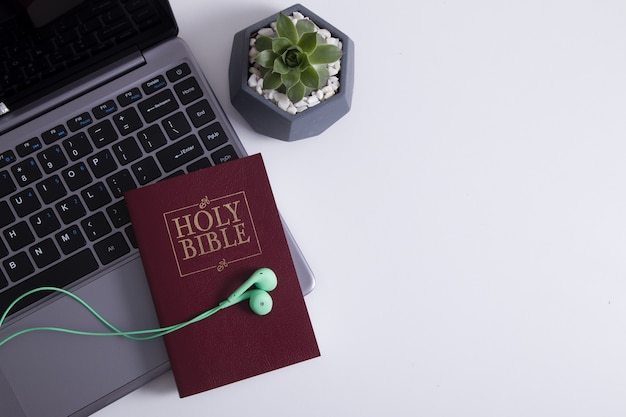 Top view of headphones on laptop and bible