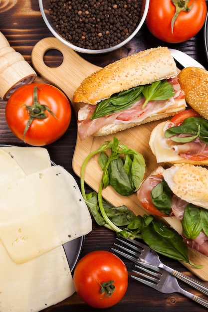 Top view on healthy sandwiches next to ingredients that it where made of on wooden table