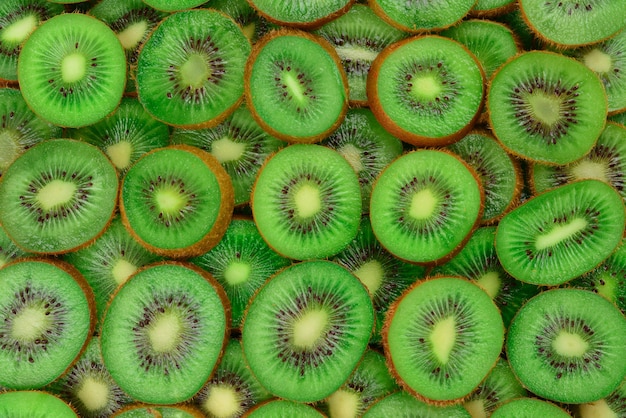 Top view of heap of sliced kiwi as textured background.