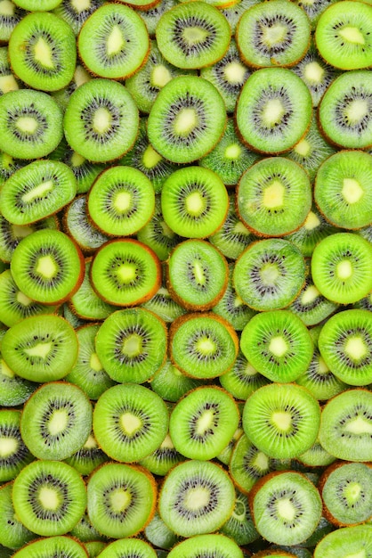 Top view of heap of sliced kiwi as textured background