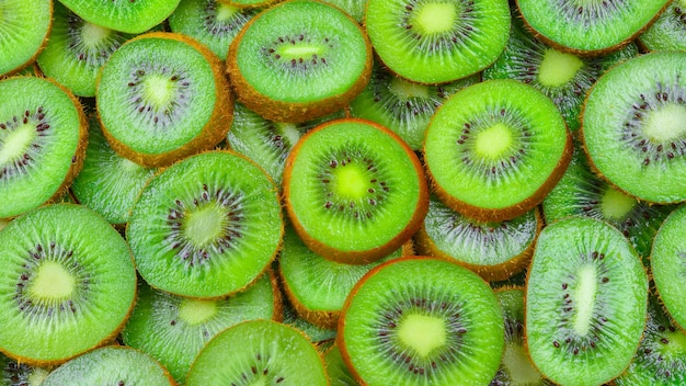 Top view of heap of sliced kiwi as textured background