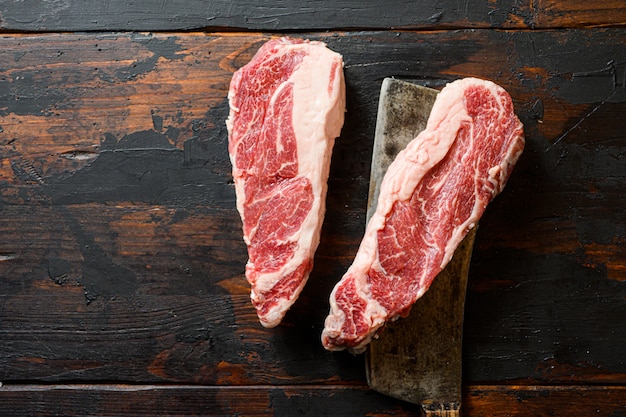 Top view of heart shape raw chuck steak with meat cleaver