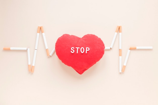 Top view heart surrounded by cigarettes