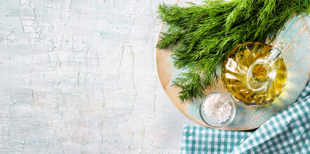 Top view of herbs, olive oil and salt on light blue background