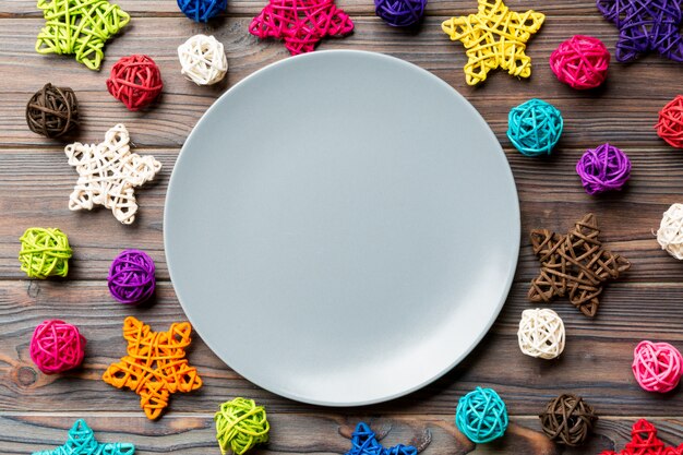 Top view of holiday plate decorated with knitted baubles and stars on wood