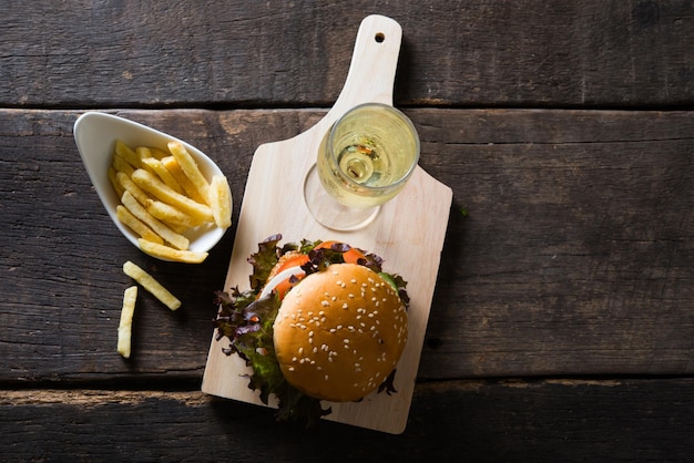 Top view of Home made chicken burger with champagnefrench fries lettuce tomato and onion on wooden board