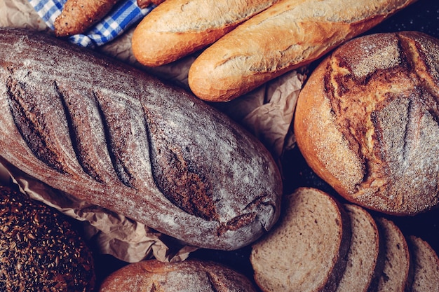 Top view of a homemade bread, slices of whole grain bread and baguette