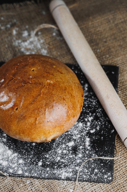 Top view of homemade bread with flour natural agricultural products Healthy and tasty pastries Whole grain bread flour Close up dark background