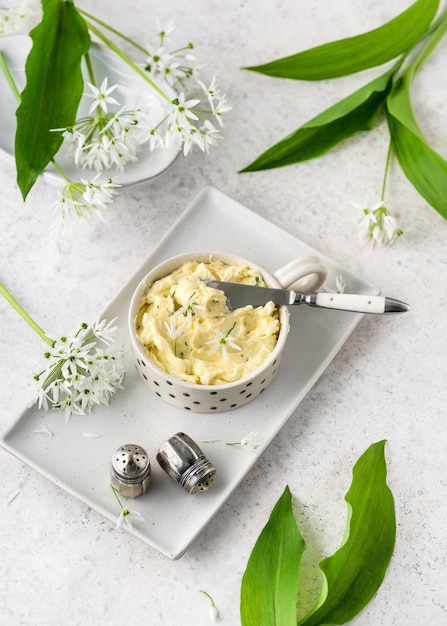 Top view of homemade herb butter with fresh wild garlic flowers Simple and healthy snacks