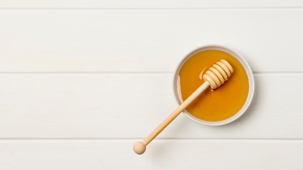 Photo top view honey bowl with spoon