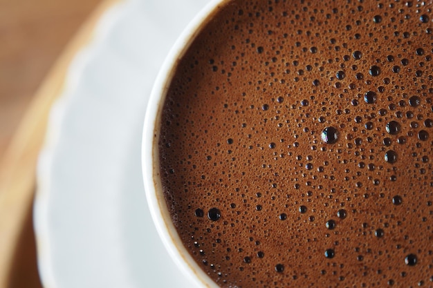 白い背景の上の泡とホット コーヒーの上から見る