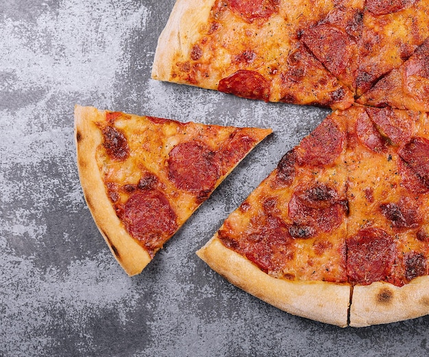 Top view of hot pepperoni pizza on stone