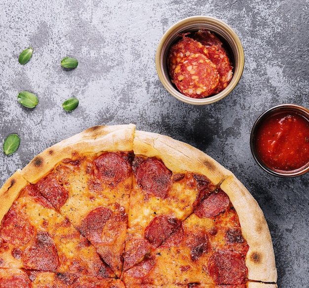 Top view of hot pepperoni pizza on stone