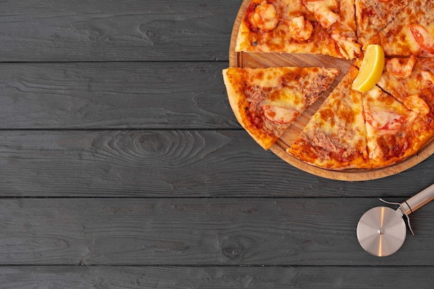 Vista dall'alto di pizza calda sul tavolo di legno nero