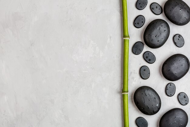 Top view of hot spa stones set for massage on gray background