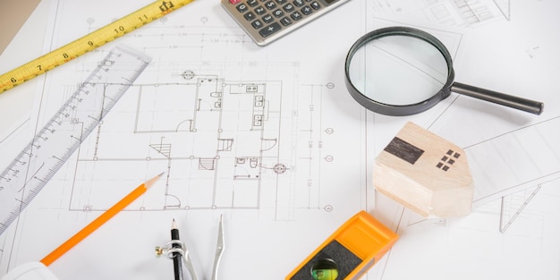 Top view of house plan blueprint paper with repair tools on\
table desk at architecture office